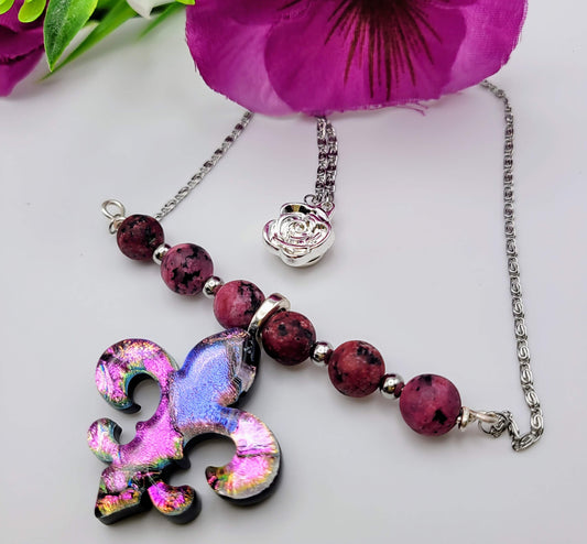 This sparkling glass bar drop necklace holds so much meaning. The Iris symbol represents courage, hope, and faith. The dazzling, handcrafted pendant is softened with semi-precious rhodonite beads meaning love, particularly loving oneself.