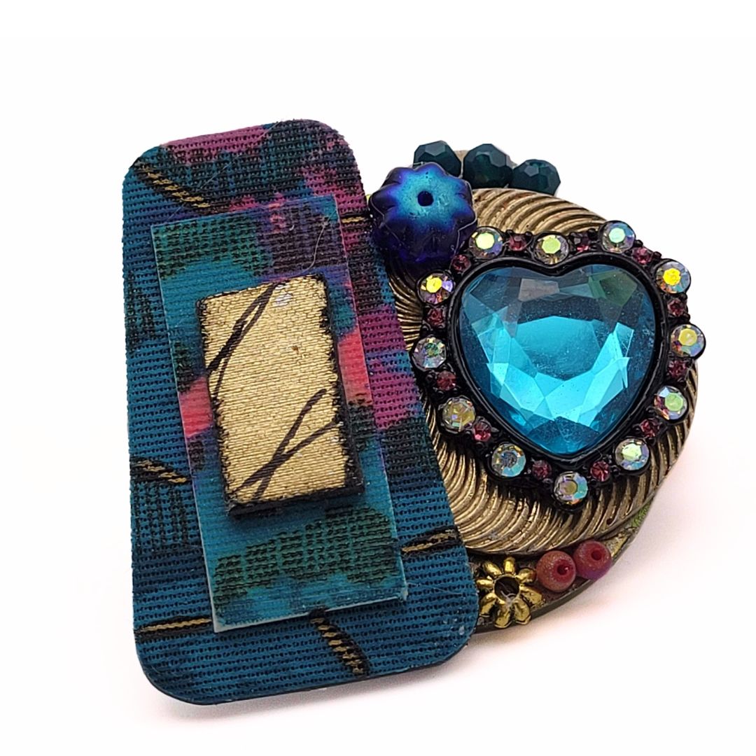 Brooches are hot! This vibrant collage is perfect to represent memories of a vibrant decade. Made with pieces from vintage jewelry including a gorgeous turquoise blue heart atop a gold pin coupled with a vintage cloth earring for extra pops of color.